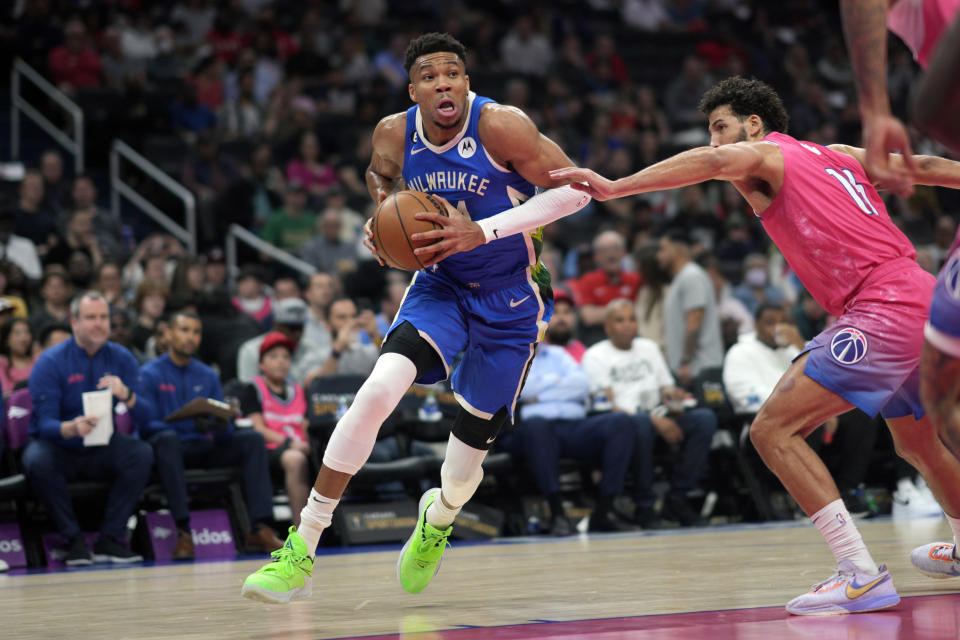 Milwaukee Bucks forward Giannis Antetokounmpo (34) dribbles past Washington Wizards forward Anthony Gill (16) to score during the first half of an NBA basketball game, Tuesday, April 4, 2023, in Washington. (AP Photo/Jess Rapfogel)