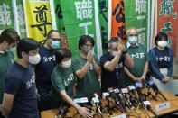 Hong Kong Confederation of Trade Unions President Joe Wong Nai-yuen, third from right, with deep blue T-shirt, gestures while posing for a photo with other members before a news conference on the possibility of disbandment in Hong Kong Sunday, Sept. 19, 2021. Hong Kong's biggest opposition trade union said Sunday it would disband, following concerns for "members' personal safety." (AP Photo/Vincent Yu)