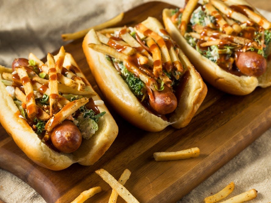 cleveland polish boy hot dogs with fries on a wooden board