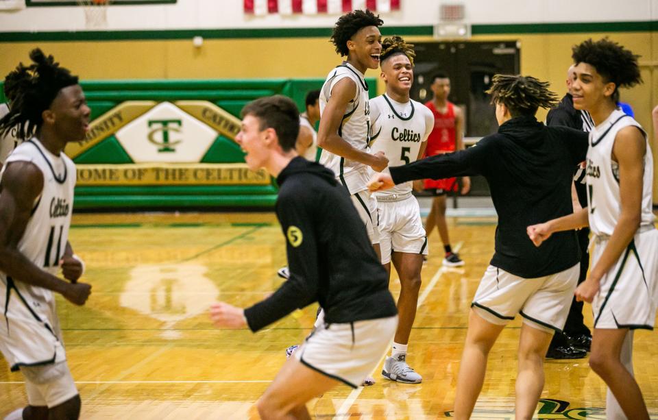 Trinity Catholic celebrates after defeating The Rock, 65-59, Friday night at home in Ocala.
