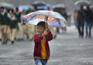 <p>An Indian boy holds an umbrella as he walks to Indian Prime Minister Narendra Modi’s first public meeting in Shillong, the capital of Meghalaya state, India, on May 27, 2016. Modi addressed the North Eastern Council meeting, with a focus on overall development of the region. Modi also inaugurated three major railway projects and laid the foundation stone of the Agartala-Akhaura railway project between India and Bangladesh. (EPA/STR) </p>