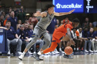 Auburn guard K.D. Johnson, right, tries to control the ball as West Virginia forward James Okonkwo, left, defends during the second half of an NCAA college basketball game on Saturday, Jan. 28, 2023, in Morgantown, W.Va. (AP Photo/Kathleen Batten)