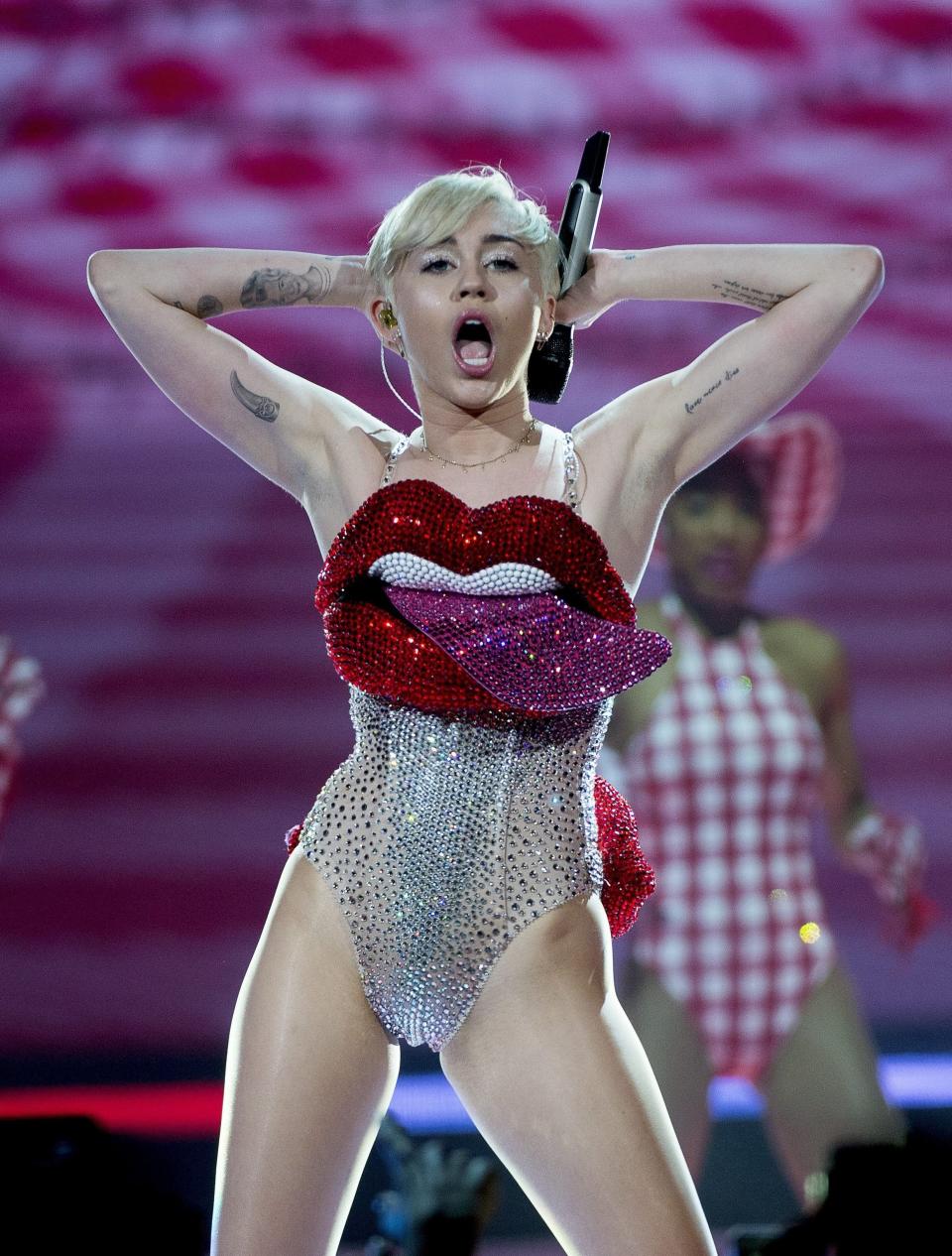 Miley performing onstage in a sparkly bodysuit