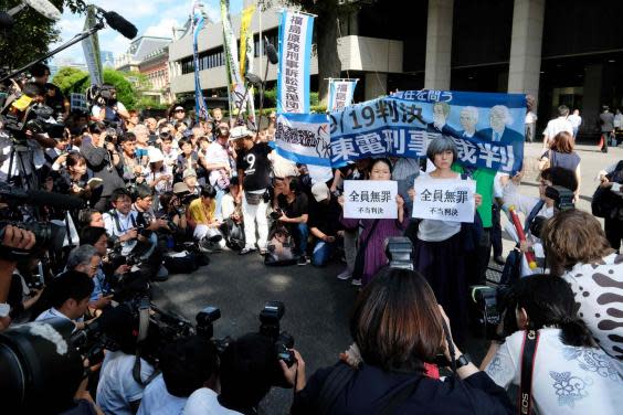 Activists hold banners in front of the Tokyo District Court in Tokyo on September 19 after the court acquitted three former officials for the Fukushima disaster. (Kazuhiro Nogi/AFP/Getty Images)
