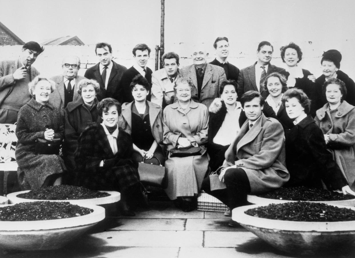 The cast of Coronation Street in the Granada TV Centre car park in Manchester, between rehearsals for the first programme networked on December 9, 1960. Only one member from the original team is William Roache. (Back row, from left) Ivan Beavis (Harry Hewitt), Jack Howarth (Albert Tatlock), Ernst Walder (Ivan Cheveski), Philip Lowrie (Dennis Tanner), Alan Rothwell (David Barlow), Arthur Leslie (Jack Walker), William Croasdale (unnamed extra), Frank Pemberton (Frank Barlow), Noel Dyson (Ida Barlow), Margot Bryant (Minnie Caldwell). (Front row) Doris Speed (Annie Walker), Betty Alberge (Florrie Lindley), Anne Cunningham (Linda Cheveski), Patrica Phoenix (Elsie Tanner), Violet Carson (Ena Sharples), Christine Hargreaves (Christine Hardman), William Roache (Ken Barlow), Patricia Shakesby (Susan Cunningham), Penny Davies (extra) and Lynne Carol (Martha Longhurst).   (Photo by PA Images via Getty Images)