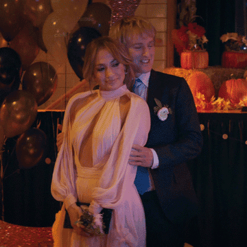 Jennifer Lopez and Owen Wilson posing for photos together in "Marry Me"