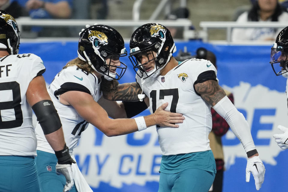 Jacksonville Jaguars quarterback Trevor Lawrence (16) pats tight end Evan Engram (17) after Engram caught a 3-yard pass for a touchdown during the second half of an NFL football game against the Detroit Lions, Sunday, Dec. 4, 2022, in Detroit. (AP Photo/Paul Sancya)