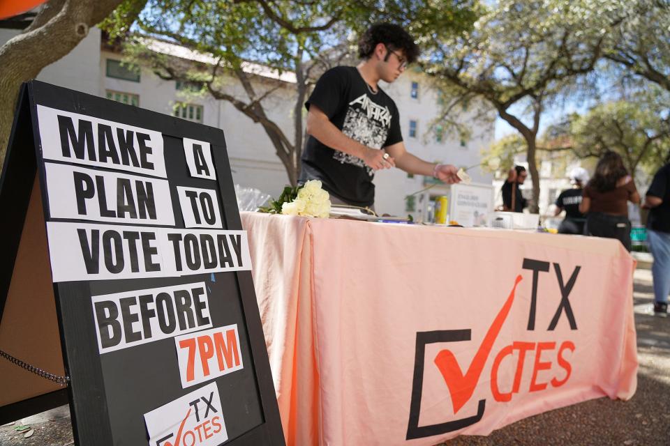 Freshman student Jesus Silva distributes information about voting, free roses, and candy outside a polling area at the FAS center at the University of Texas on Tuesday, March 5, 2024, in preparation for Super Tuesday.