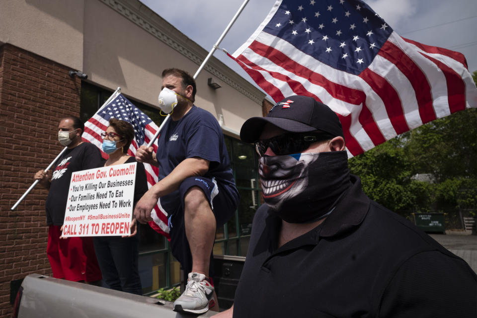 A group of supporters shows up for Bobby Catone, the owner of a Staten Island tanning salon, Thursday, May 28, 2020, in New York. Catone opened the salon briefly Thursday morning in defiance of a law requiring non-essential businesses to remain closed during the coronavirus pandemic. (AP Photo/Mark Lennihan)