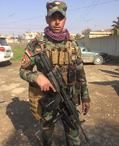 A typical Iraqi soldier, heavily armed with a cigarette in hand