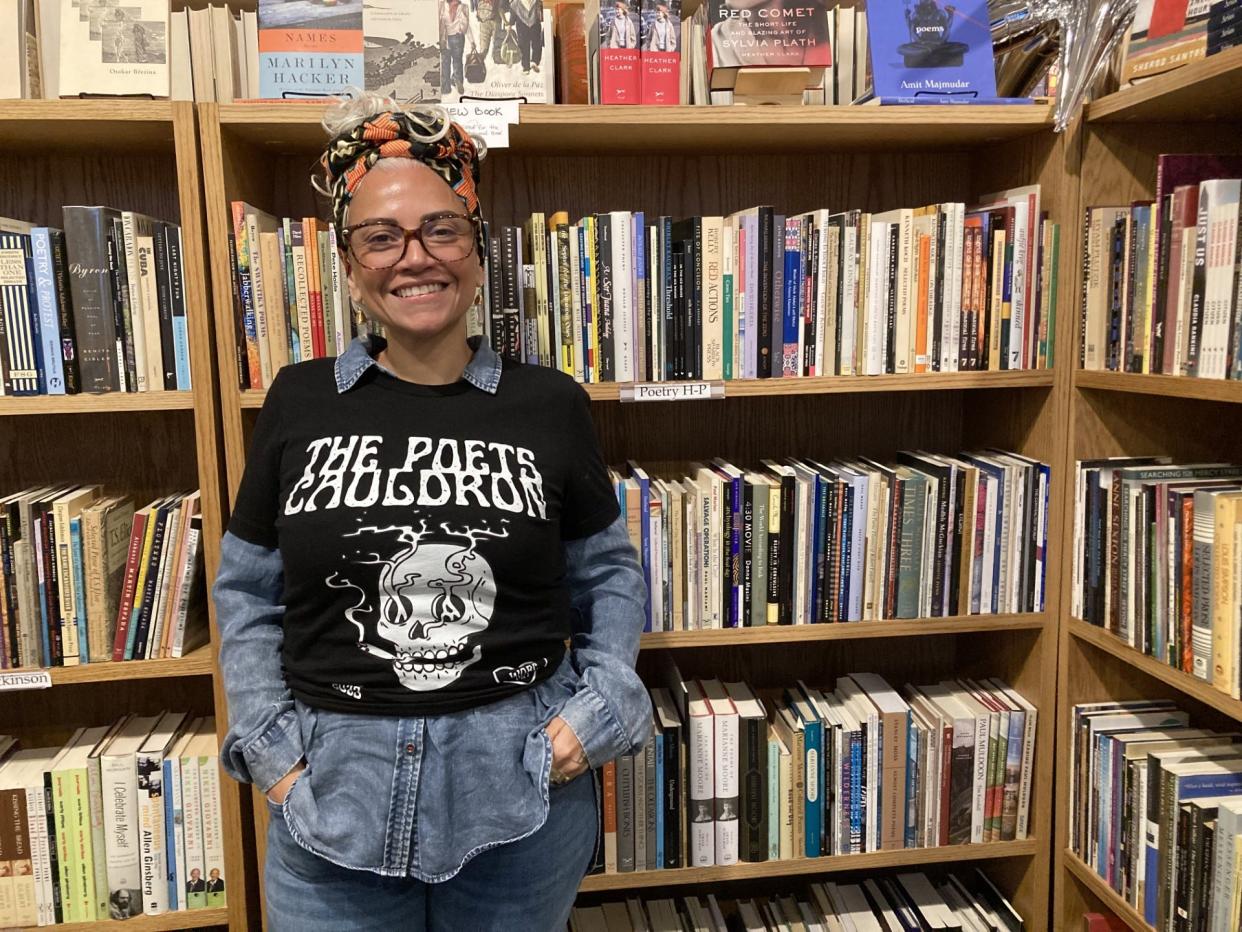 Worcester poet Bruja The Villain, founder of the monthly Poets Cauldron reading and open mic, poses in front of the poetry section at Bedlam Book Café in Worcester. Bruja will host the upcoming Worcester preliminary youth poetry slam April 25.