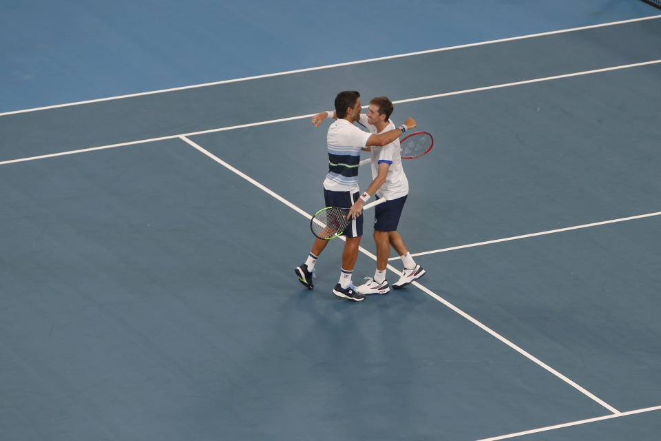 Argentina's Maximo Gonzalez and Andres Molteni embrace each other after winning the doubles match against Poland's Hubert Hurkacz and Lukasz Kubot during their ATP Cup tennis match in Sydney, Saturday, Jan. 4, 2020. (AP Photo/Steve Christo)