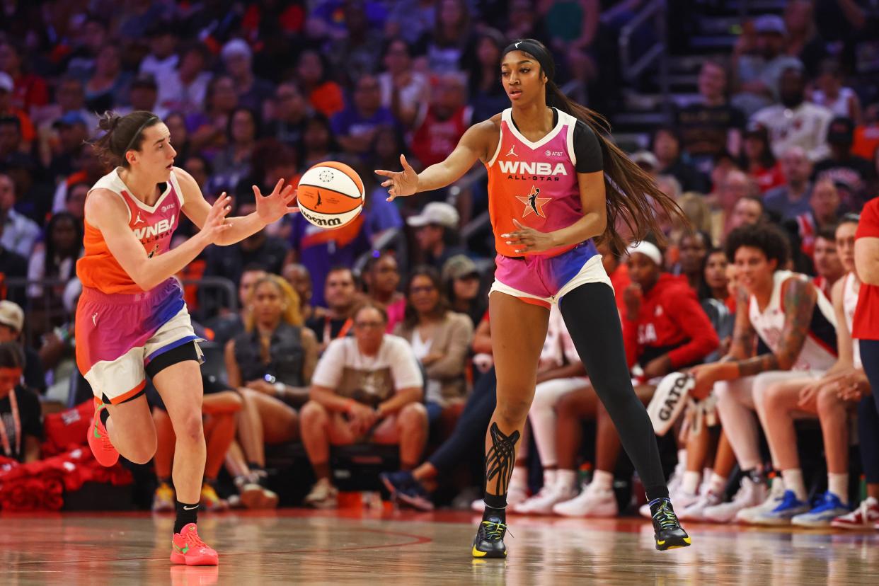 Angel Reese, right, passes to Caitlin Clark during the WNBA All-Star Game.