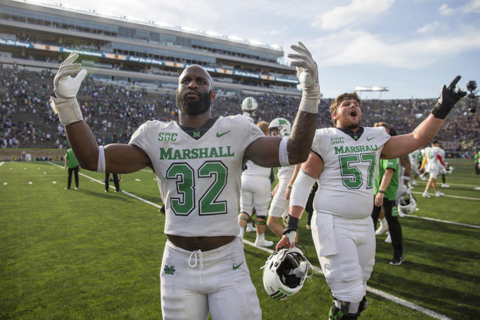 Marshall's Koby Cumberlander (32) and Eric Meeks (57) celebrate after the team defeated Notre Dame in an NCAA college football game Saturday, Sept. 10, 2022, in South Bend, Ind. Marshall won 26-21. (Sholten Singer/The Herald-Dispatch via AP)