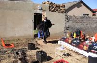 A clergyman of the Gabula church, arrives carrying a crate of empty beer bottles