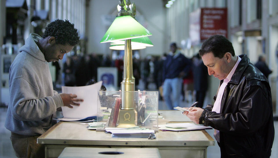 Kareem Lake (L) and Steve Harrison prepare their tax forms for mailing at the James A. Farley Post Office building in New York City. (Photo by Mario Tama/Getty Images)