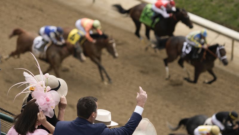 People react as they watch a horse race at Churchill Downs Saturday, May 6, 2023, in Louisville, Ky. The 2023 Kentucky Derby favorite horse, Forte, was scratched from the race.