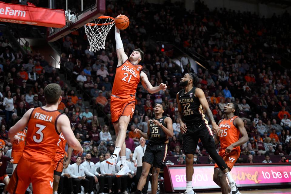 Virginia Tech Hokies forward Grant Basile (21) shoots the ball against Florida State Seminoles guard Darin Green Jr. (22) and guard Matthew Cleveland (35) at Cassell Coliseum.March 4.