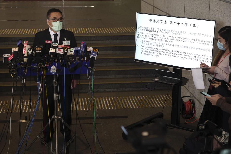 Senior superintendent of National Security Department Li Kwai-wah talks to reporters next to a TV screen displaying the National Security No. 22 during a press conference in Hong Kong Wednesday, Jan. 6, 2021. About 50 Hong Kong pro-democracy figures were arrested by police on Wednesday under a national security law, following their involvement in an unofficial primary election last year held to increase their chances of controlling the legislature, according to local media reports. (AP Photo/Vincent Yu)