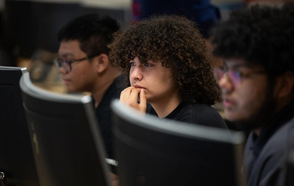 Joey Gomez, middle, Ryan Stead, right, and Ethan Pajo, left, work on a cybersecurity challenge during a computer science Hackathon at Enochs High School in Modesto, Calif., Saturday, May 11, 2024.