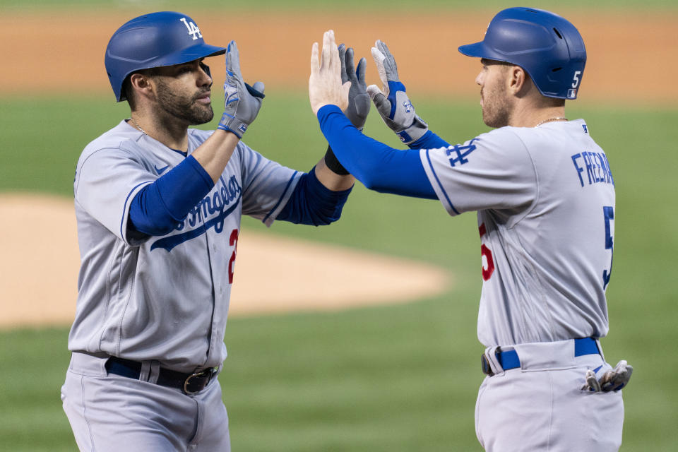 Los Angeles Dodgers designated hitter J.D. Martinez, left, celebrates with teammate reddie Freeman, right, after hitting a two-run home run during the first inning of a baseball game against the Washington Nationals, Friday, Sept. 8, 2023, in Washington. (AP Photo/Stephanie Scarbrough)