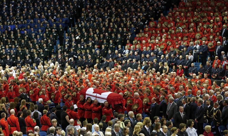 Pallbearers carry the casket of one of three Royal Canadian Mounted Police officers who were killed last week during a regimental funeral in Moncton