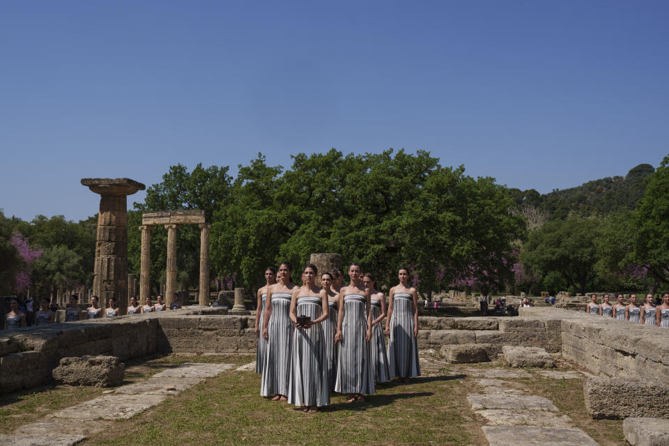 Performers, who will take part in the flame lighting ceremony for the Paris Olympics, join a rehearsal at Ancient Olympia site, Greece, Sunday, April 14, 2024. Every two years, a countdown to the Olympic games is launched from its ancient birthplace with a flame lighting ceremony in southern Greece at Ancient Olympia. The event is marked with a performance by dancers who assume the role of priestesses and male companions, their movement inspired by scenes on millennia-old artwork. (AP Photo/Petros Giannakouris)