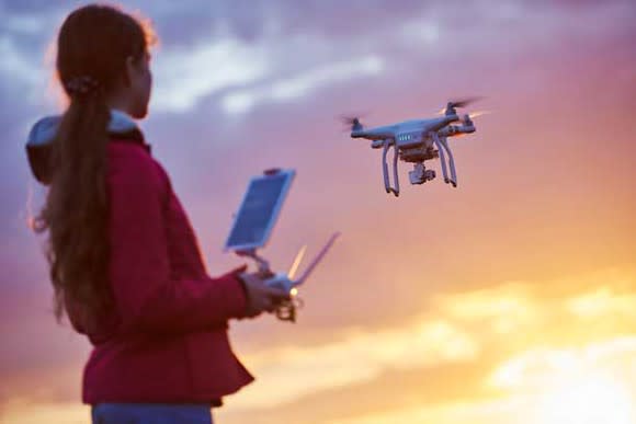 A woman flying a drone.