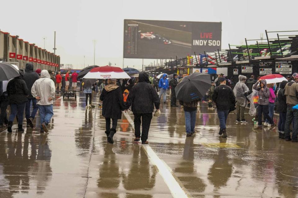 Fans walk in the garage area in the rain before the Coca-Cola 600 at Charlotte Motor Speedway in Concord, N.C., Sunday.