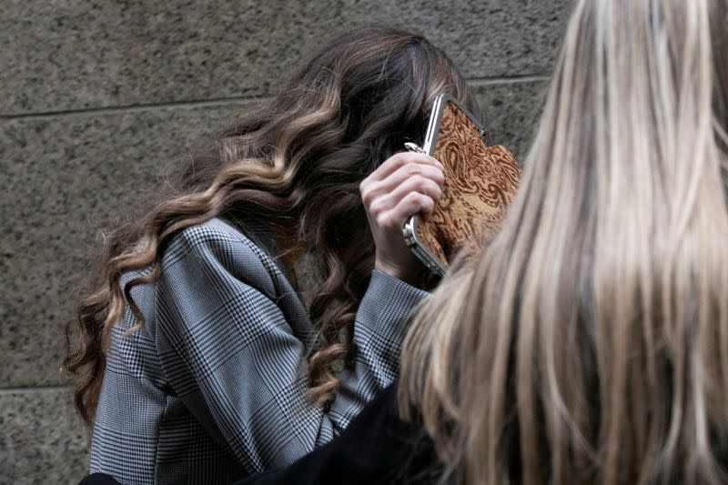 Witness Lauren Young hides her face as she departs the Criminal Court after testifying during the Harvey Weinstein sexual assault trial trial in Manhattan