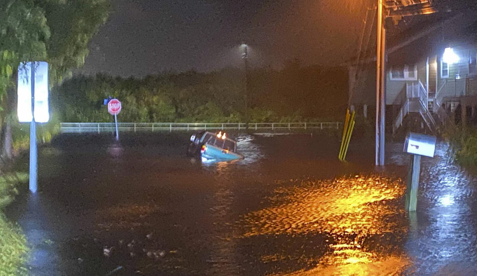 A vehicle lists in floodwaters late Wednesday, Nov. 11, 2020, as Tropical Storm Eta nears Safety Harbor, Fla. (Luis Santana/Tampa Bay Times via AP)