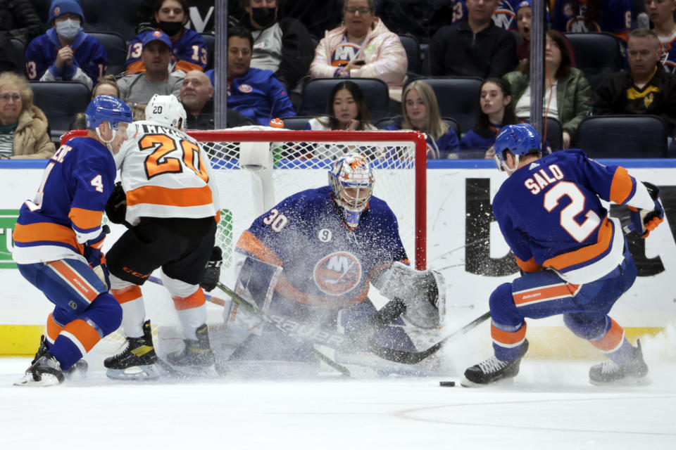 New York Islanders goaltender Ilya Sorokin (30) defends the goal as defenseman Robin Salo (2) as Andy Greene (4) and Philadelphia Flyers center Gerry Mayhew (20) look on during the second period of an NHL hockey game, Tuesday, Jan. 25, 2022, in Elmont, N.Y. (AP Photo/Corey Sipkin).