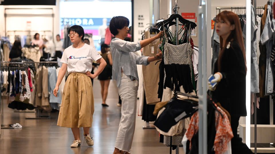 A woman selects clothes at a shopping mall in Beijing on June 15, 2023. - Wang Zhao/AFP/Getty Images