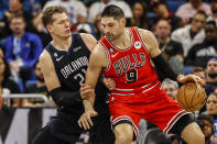 Orlando Magic center Moritz Wagner (21) defends against Chicago Bulls center Nikola Vucevic (9) during the first half of an NBA basketball game Saturday, Jan. 28, 2023, in Orlando, Fla. (AP Photo/Kevin Kolczynski)