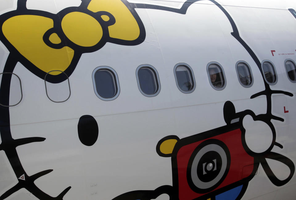 A passenger looks out of an Airbus A330-300 aircraft of Taiwan's Eva Airlines, decorated with Hello Kitty motifs, in Taoyuan International Airport, northern Taiwan, April 30, 2012. Taiwan's second-largest carrier, Eva Airlines, and Japan's comic company, Sanrio, which owns the Hello Kitty brand, collaborated on the second generation Hello Kitty-themed aircraft which was launched on October 2011. There are currently three Hello Kitty-themed Airbus A330-300 aircrafts flying between cities such as Taipei, Fukuoka, Narita, Sapporo, Incheon, Hong Kong and Guam. REUTERS/Pichi Chuang