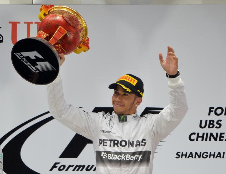 Mercedes driver Lewis Hamilton of Britain celebrates on the podium after winning the Formula One Chinese Grand Prix in Shanghai on April 20, 2014