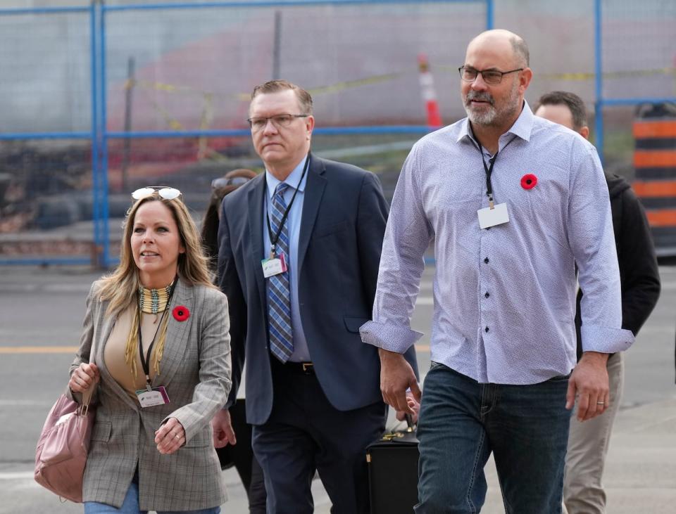 Freedom Convoy organizers Tamara Lich, left, and Chris Barber, right, make their way with counsel Keith Wilson to the Public Order Emergency Commission Nov. 1, 2022 in Ottawa. The pair are set to face a criminal trial on Tuesday. 