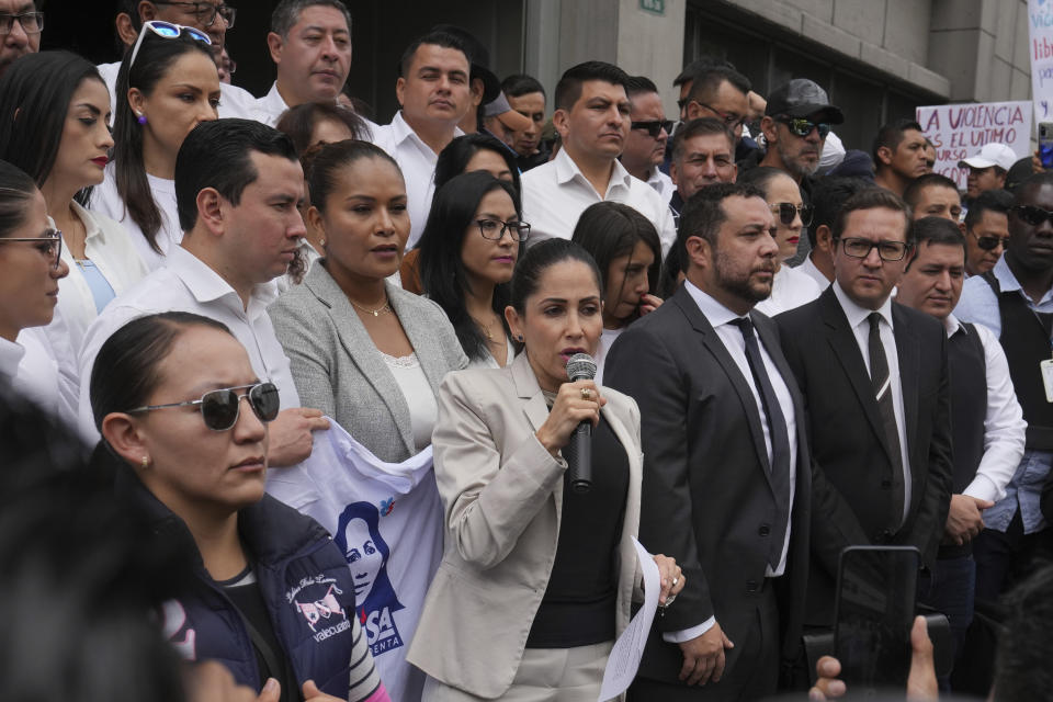 La aspirante presidencial Luisa González, del Movimiento Revolución Ciudadana, habla ante sus seguidores rodeada de seguridad a su salida de la Fiscalía General, adonde presentó una denuncia por un presunto plan para matarla en Quito, Ecuador, el lunes 18 de septiembre de 2023. Los ecuatorianos irán a segunda vuelta presidencial el 15 de octubre, tras el asesinato de uno de los candidatos presidenciales. (AP Foto/Dolores Ochoa)