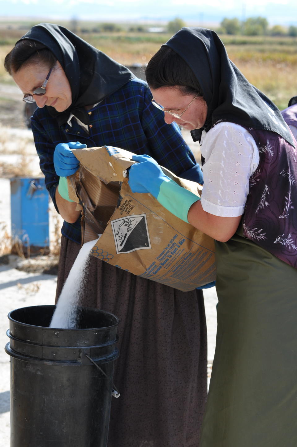 This undated image released by National Geographic Channels shows Hutterites Rita Hofer and Sarah Hofer pouring lye for soap in King Colony, Mont. "Meet the Hutterites," a National Geographic documentary series about a small religious colony in rural Montana, debuts Tuesday, May 29. (AP Photo/National Georgraphic, Ben Shank)