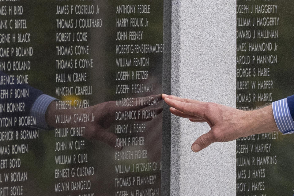 FILE - President Joe Biden reaches to touch the name of his uncle Ambrose J. Finnegan, Jr., on a wall at a Scranton war memorial, April 17, 2024, in Scranton, Pa. His uncle died in WWII. After the United States was pulled into World War II by Japan's surprise deadly bombing campaign at Pearl Harbor, Hawaii, Ambrose Finnegan and his three brothers, John, Edward and Gerard, uncles of President Joe Biden, were among the tens of thousands of young Americans who felt the call to join the military and help defend their country. (AP Photo/Alex Brandon, File)