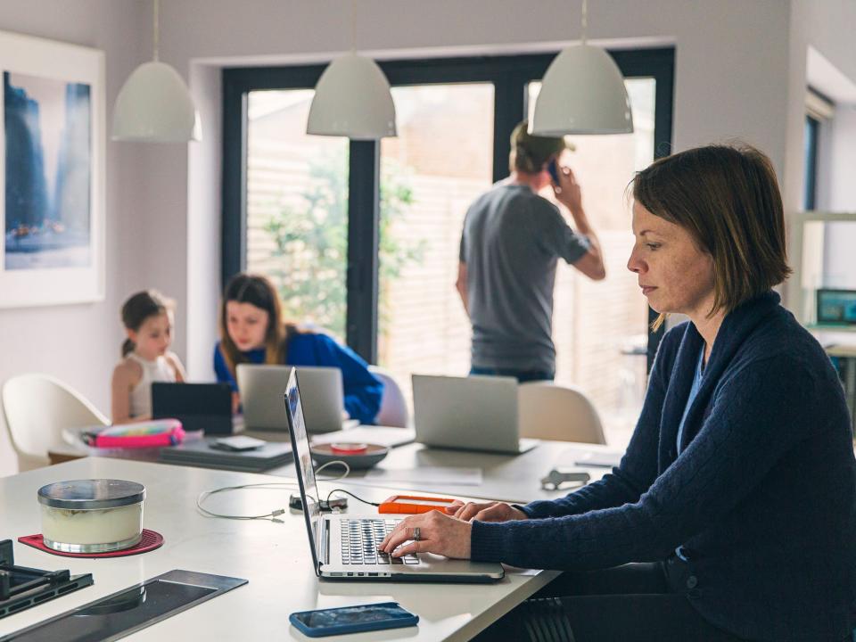 Woman working in kitchen on laptop