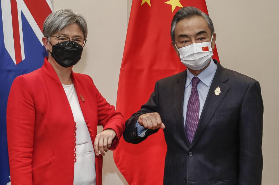 Australia's Foreign Minister Penny Wong (L) bumps elbows with China's Foreign Minister Wang Yi during their bilateral meeting on the sidelines of G20 Foreign Ministers Meeting in Nusa Dua on Indonesia's resort island of Bali on July 8, 2022.