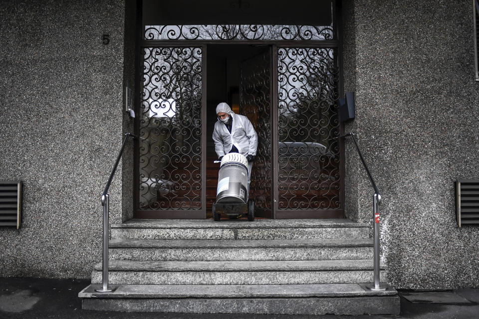 Un empleado entrega un tanque de oxígeno a enfermos de coronavirus que reciben tratamiento domiciliario en Bergamo, Italia, martes 31 de marzo de 2020. (Claudio Furlan/LaPresse via AP)