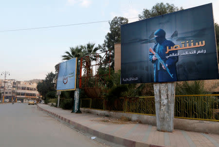 FILE PHOTO: Islamic State billboards are seen along a street in Raqqa, eastern Syria, which is controlled by the Islamic State, October 29, 2014. The billboard (R) reads: "We will win despite the global coalition". REUTERS/Nour Fourat