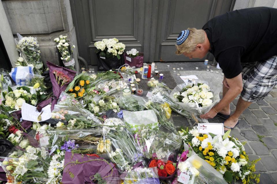 A passer-by puts down flowers at the entrance of the Jewish Museum, site of a shooting in central Brussels