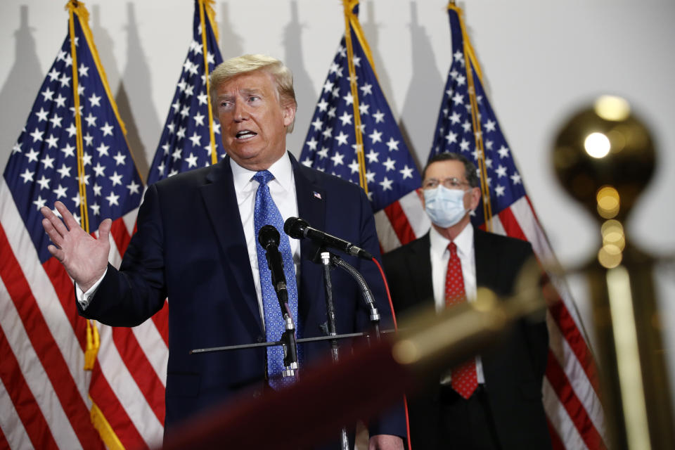 President Donald Trump speaks with reporters after meeting with Senate Republicans at their weekly luncheon on Capitol Hill in Washington, Tuesday, May 19, 2020. Standing behind Trump is Sen. John Barrasso, R-Wyo. (AP Photo/Patrick Semansky)