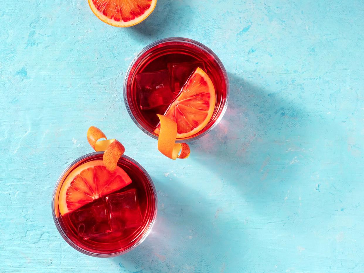 overhead of two negroni cocktails on a turquoise surface