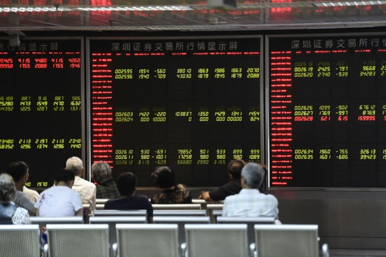 Investors look at screens showing stock market movements at a securities company in Beijing, China, on August 25, 2015