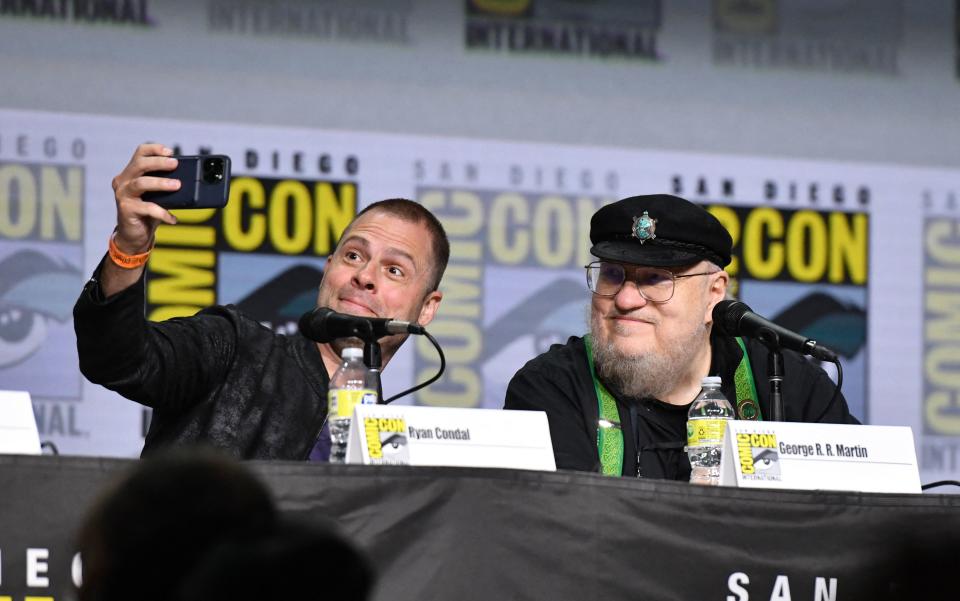 Screenwriter Ryan Condal and author George R. R. Martin take a selfie onstage at the HBO House of the Dragon panel during Comic-Con International in San Diego, California, July 23, 2022. (Photo by Chris Delmas / AFP) (Photo by CHRIS DELMAS/AFP via Getty Images)