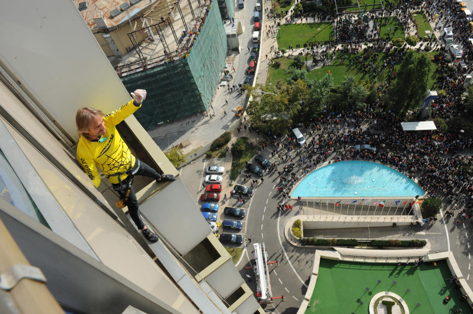 French urban climber Alain Robert, also known as the French Spiderman, celebrates after reaching the top floor of a 22-storey hotel building in Bucharest October 14, 2011. REUTERS/Flanco/Handout